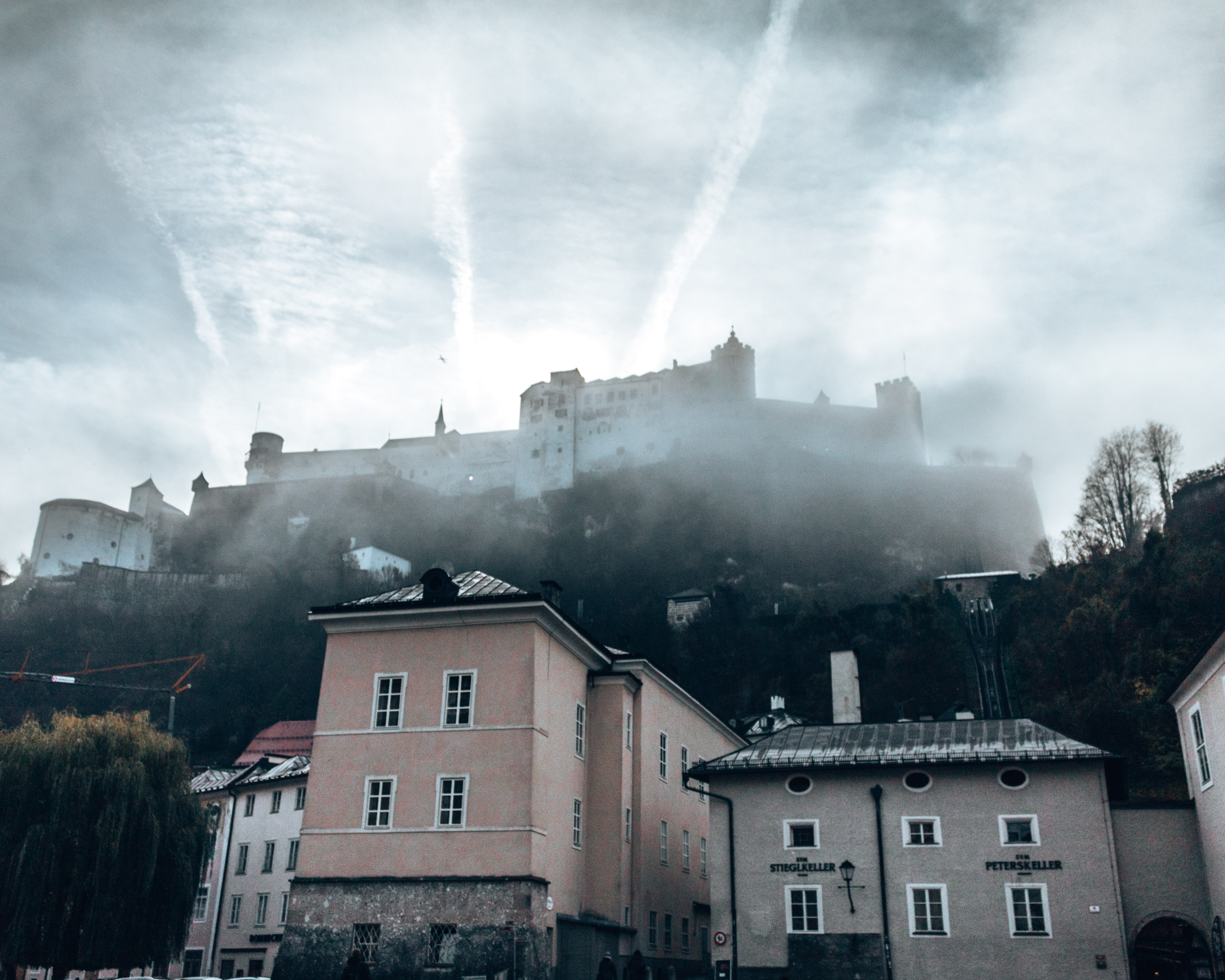 The Hohensalzburg Fortress seen through the early morning fog in Salzburg, Austria. What to do in Salzburg in 2 days in December